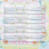 Set of four clear foldable Mahjong tile racks displayed on a floral mat