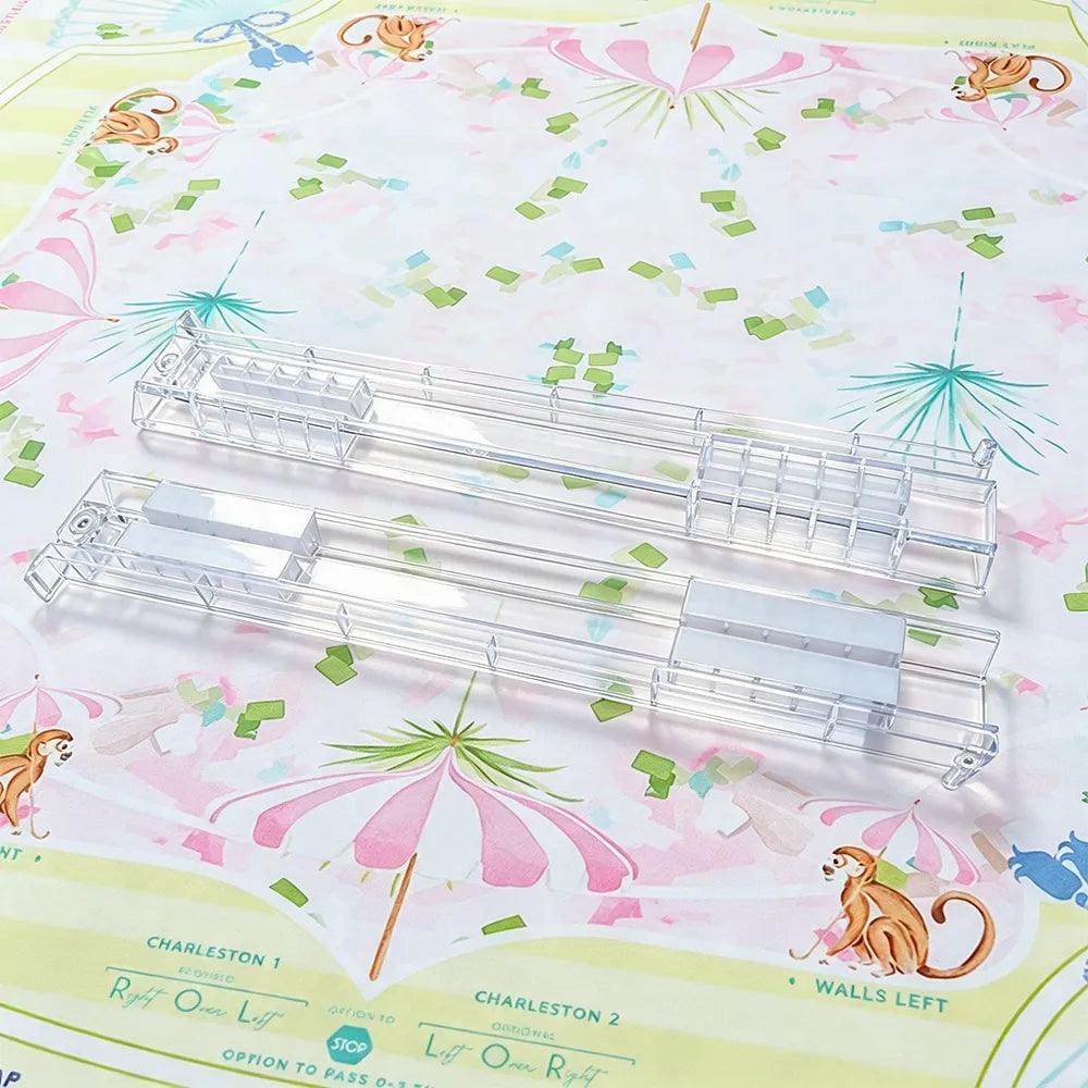 Clear foldable Mahjong tile racks arranged on a floral Mahjong mat