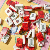 Red gemstone crane acrylic Mahjong tiles displayed beside the product packaging