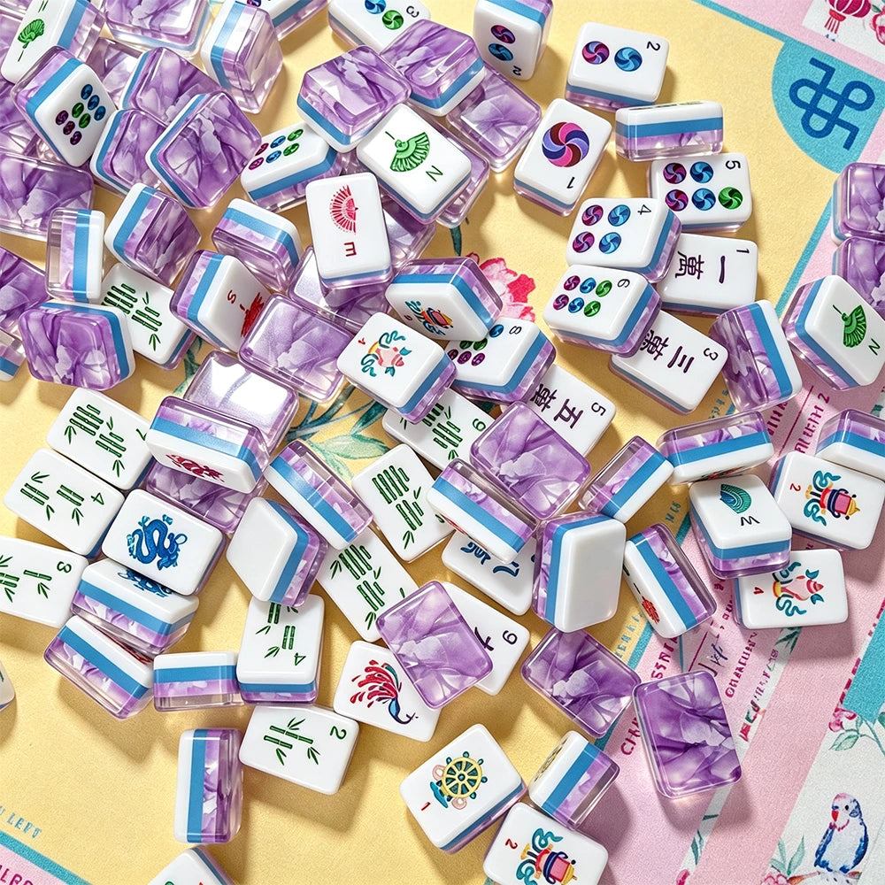 Purple marbled acrylic Mahjong tiles with hand-illustrated character, bamboo and dot suits scattered on a bird and floral pattern mat