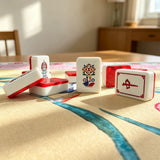 Red gemstone crane acrylic Mahjong tiles displayed upright on a tabletop