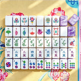 Full layout of hand-illustrated Mahjong tiles including flower, wind, dragon, bamboo, character and dot suits on a floral yellow mat with a purple marbled acrylic tile