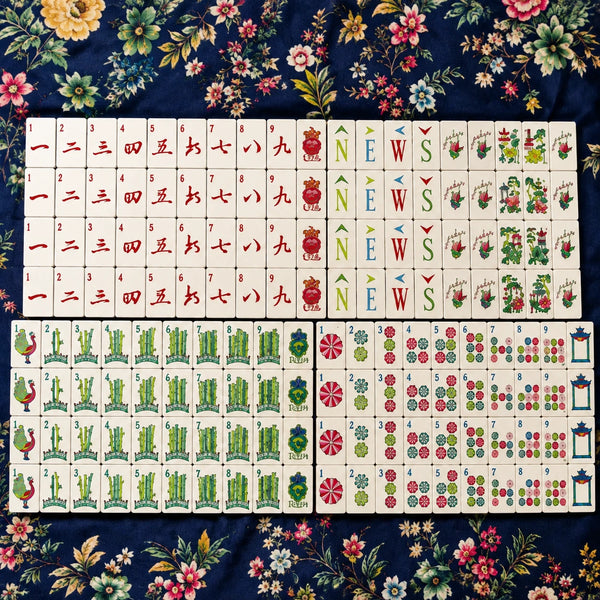 Full Mahjong tile set arranged in neat rows on a dark blue background