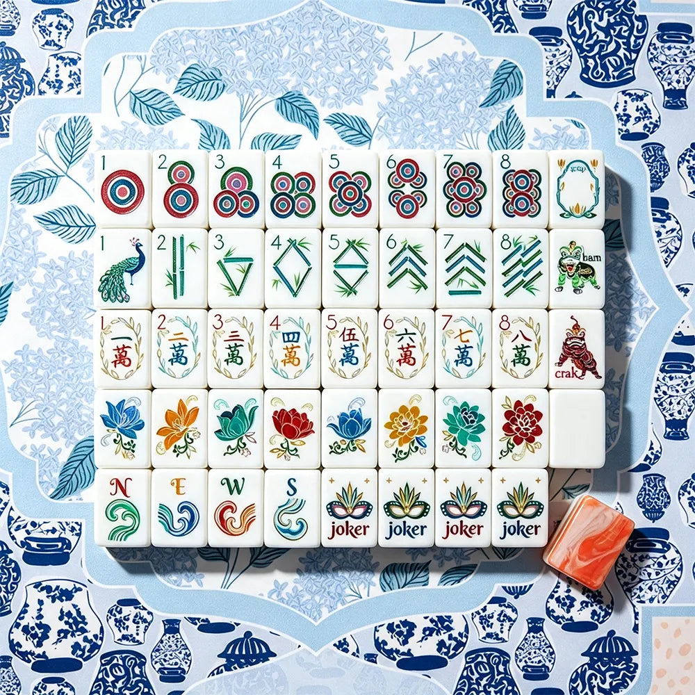 Full layout of hand-illustrated Mahjong tiles on a blue chinoiserie mat with a coral marbled acrylic tile