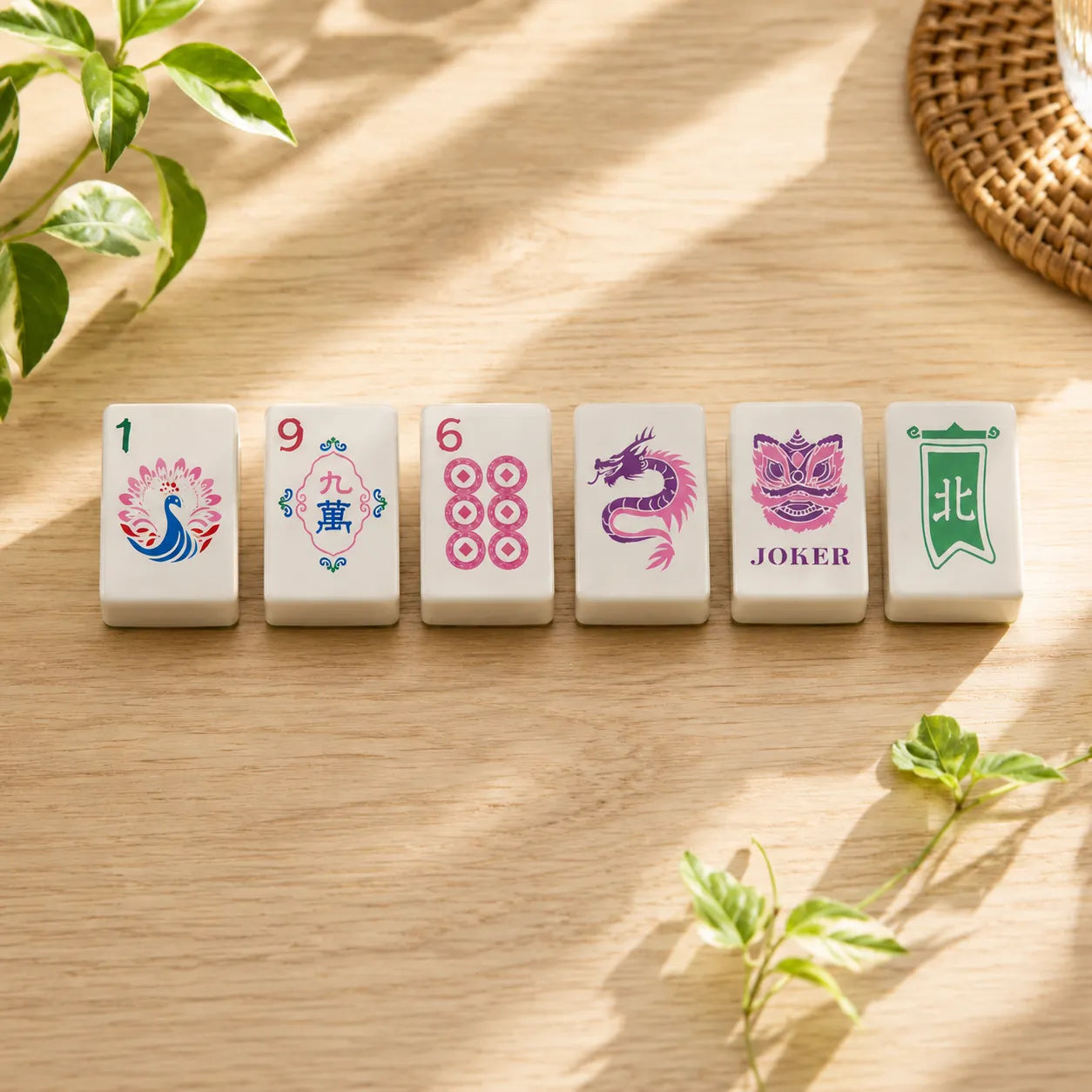 Colorful Mahjong tiles standing in a row on wood table with peacock and dragon designs