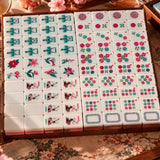 Full American mahjong set with floral, wind, dragon and umbrella dot tiles arranged in a wooden tray