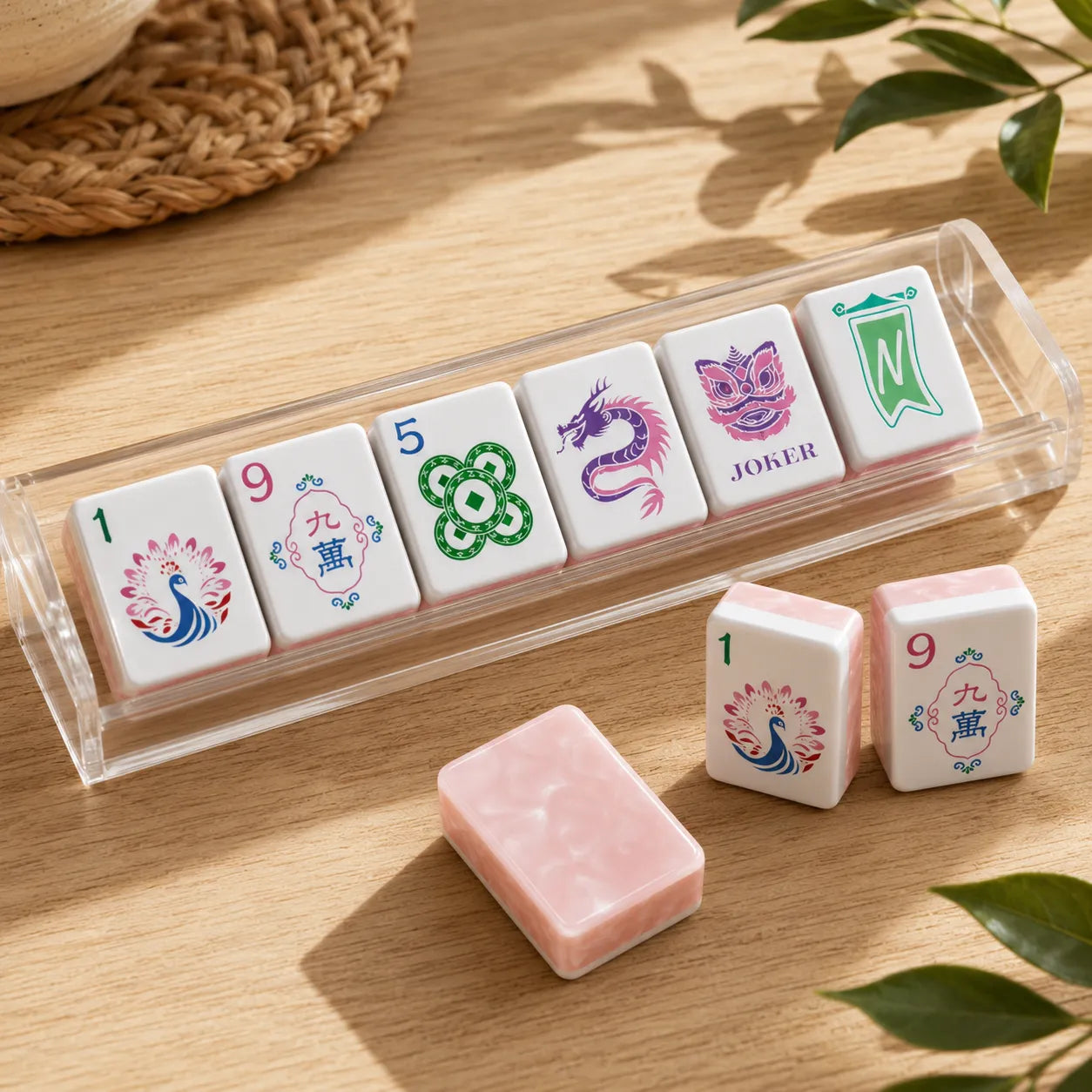 Colorful Mahjong tiles in acrylic rack with pink marble backs on wood table