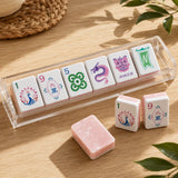 Colorful Mahjong tiles in acrylic rack with pink marble backs on wood table