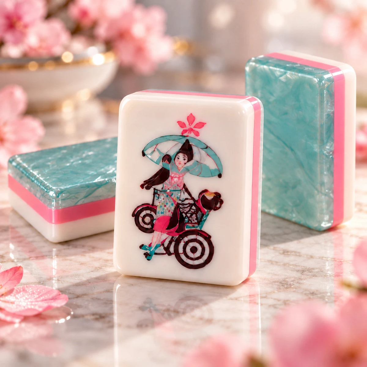 Joker mahjong tile with a woman holding an umbrella on a bicycle beside teal pearlescent tile backs with pink layers