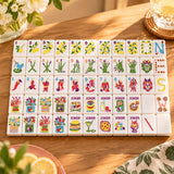 Food-themed American mahjong set with lemon, asparagus and chili pepper suit tiles and food joker tiles laid out on a wooden table