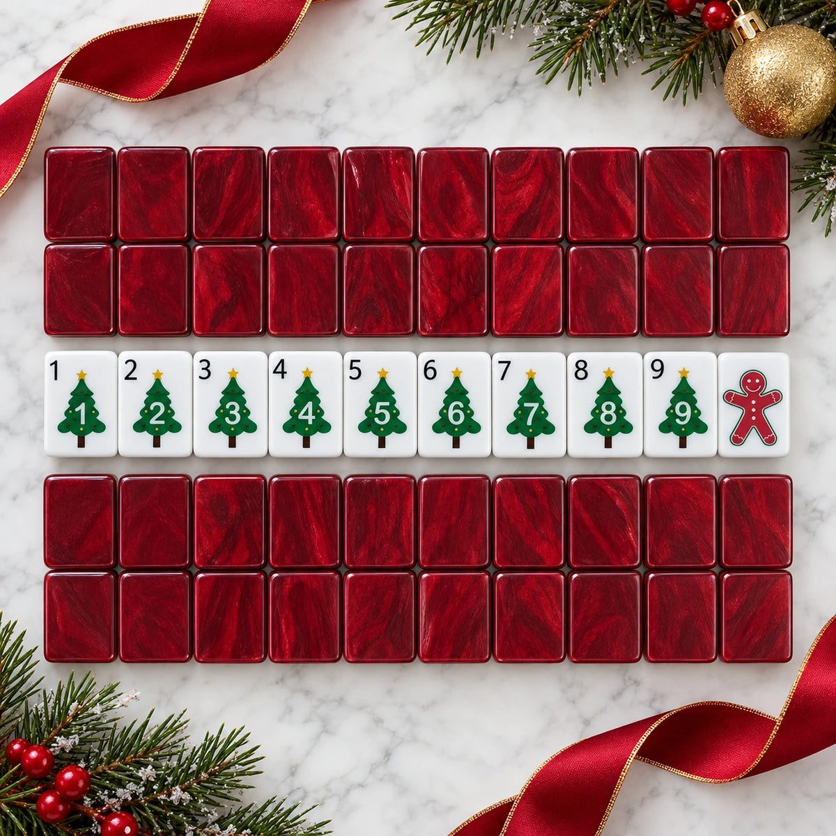 Red acrylic mahjong tile backs with numbered Christmas tree tiles and a gingerbread man tile on marble
