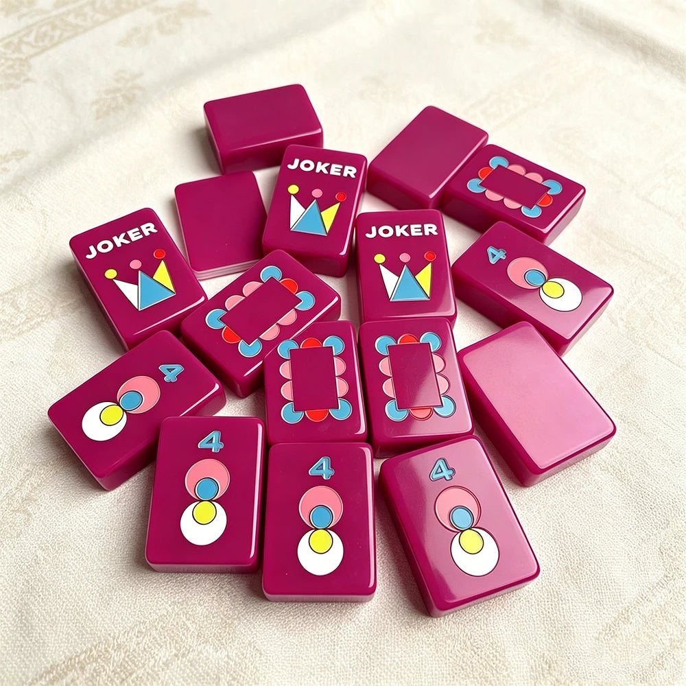 Neon purple single-layer mahjong tile set with colourful engraved designs displayed on a soft fabric surface