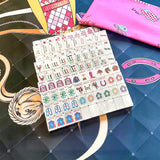 Black and pink mahjong set displayed with elegant accessories