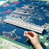 Mahjong tile pusher tool displayed with stacked tiles on a traditional mahjong table