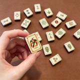 Brown mahjong tile set displayed with elegant accessories