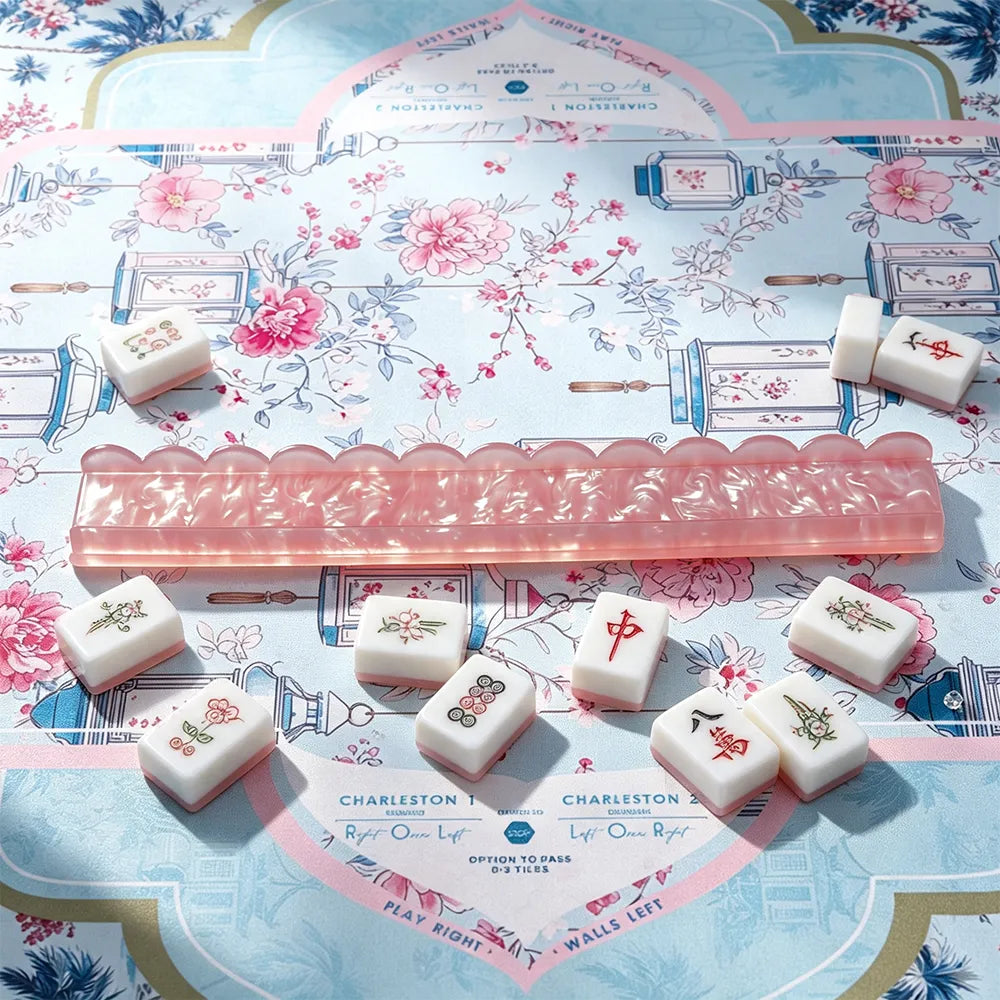 Pink acrylic mahjong tile pusher displayed with mahjong tiles on a decorative game table