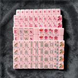 Pink mahjong tiles arranged in a stylish storage case